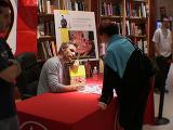 Viggo signs a copy of his book for Arwen - (640x480, 178kB)